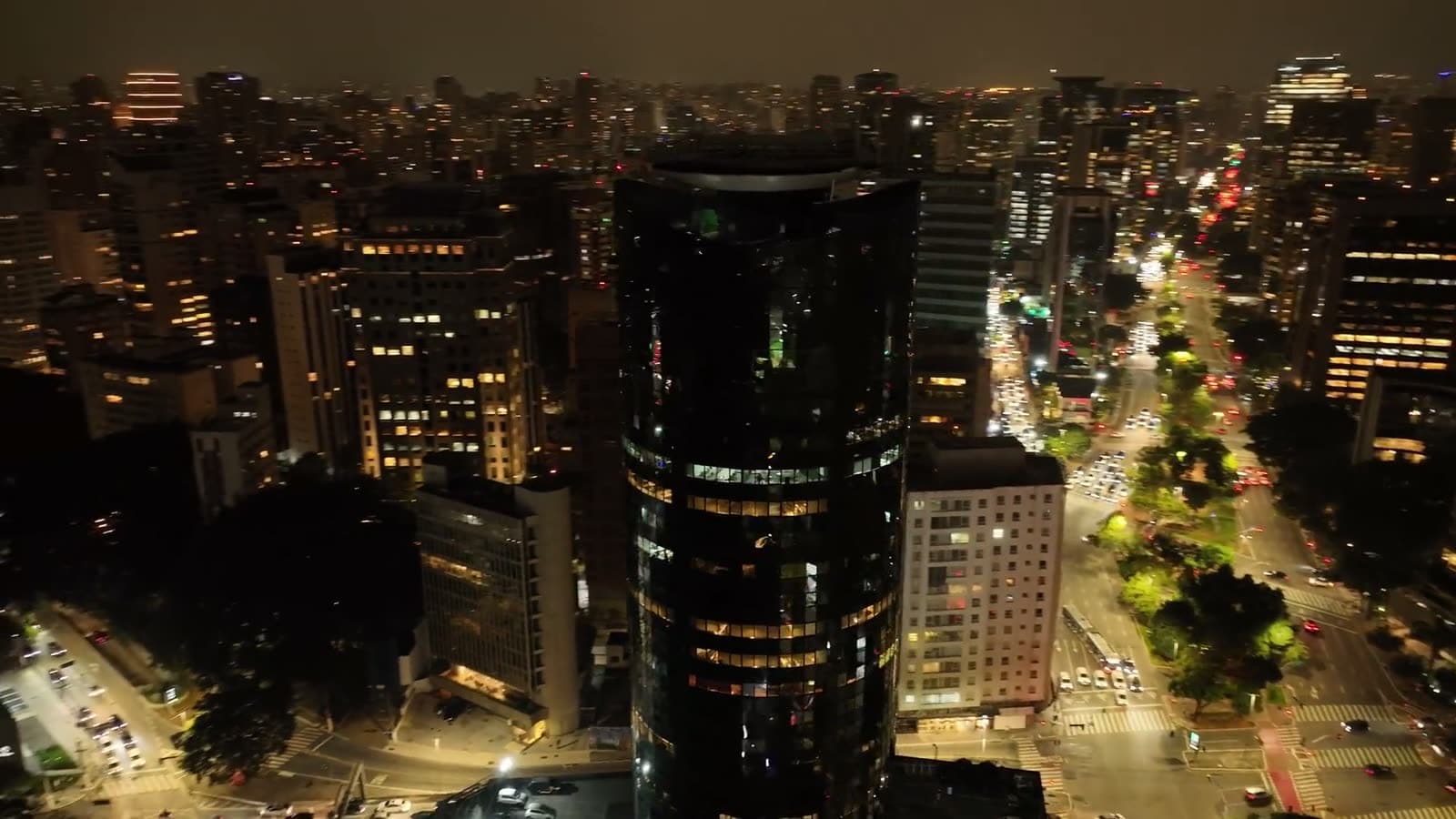 Vista aérea noturna de São Paulo, com avenidas e prédios iluminados