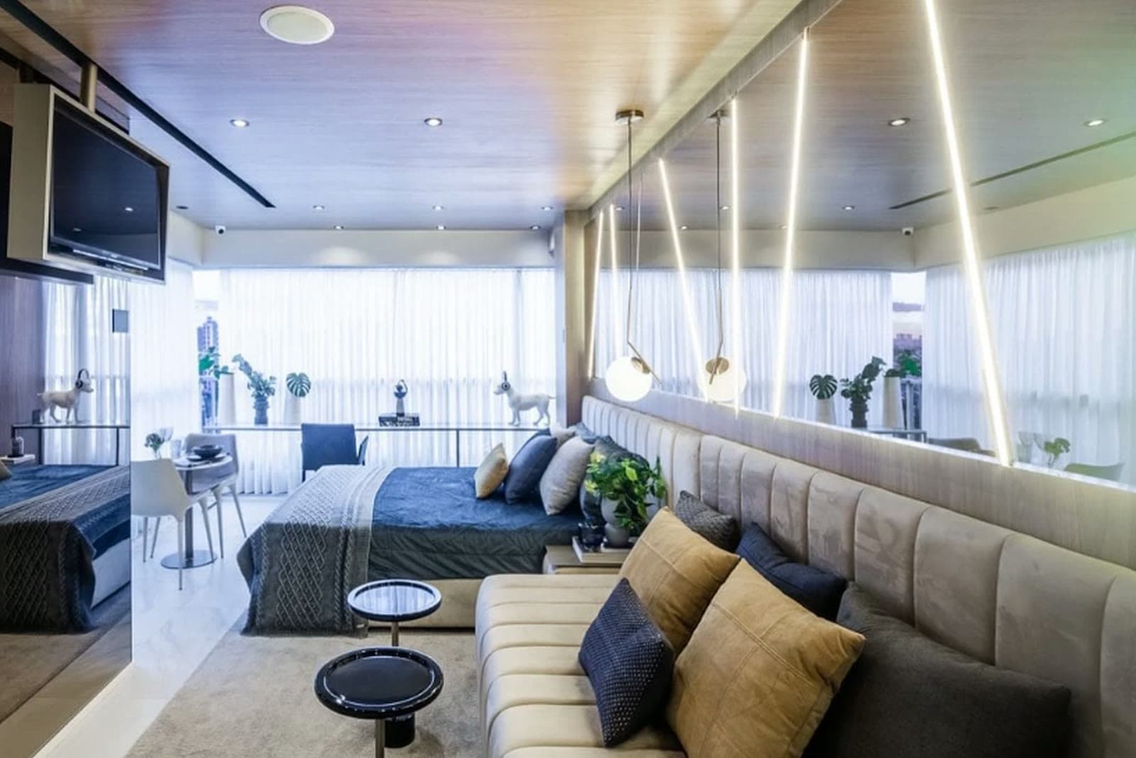Studio decorado com cama, bancada e marcenaria planejada, preparado para locação
