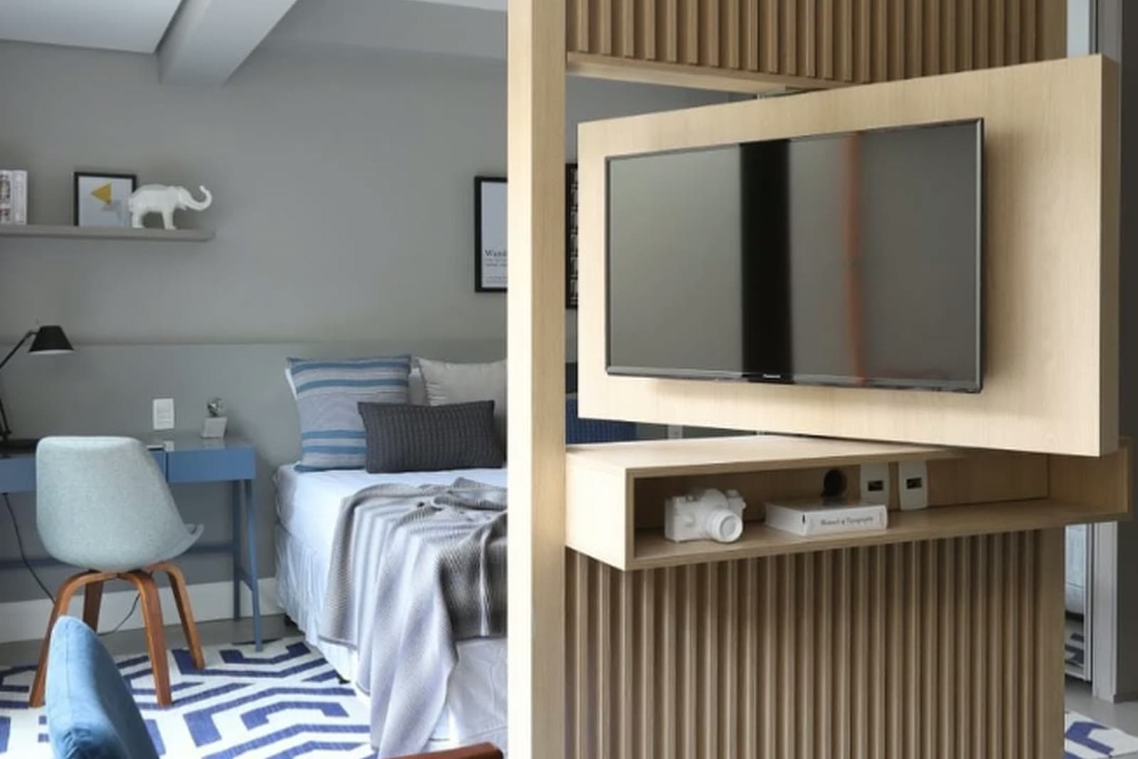 Studio decorado com marcenaria planejada, painel de TV e área de trabalho integrada