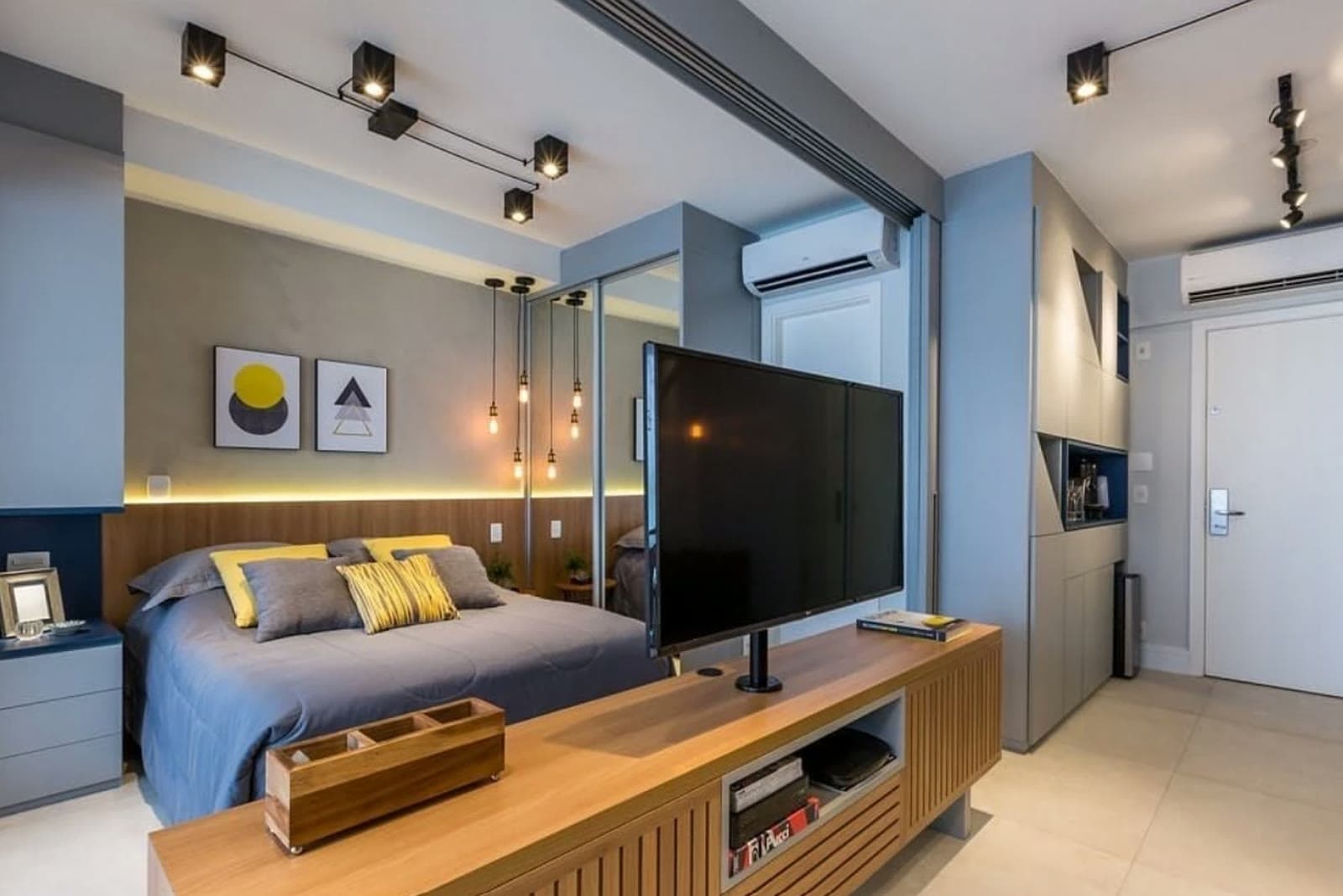 Studio decorado com cama, painel de TV e marcenaria planejada, em bairro residencial de São Paulo
