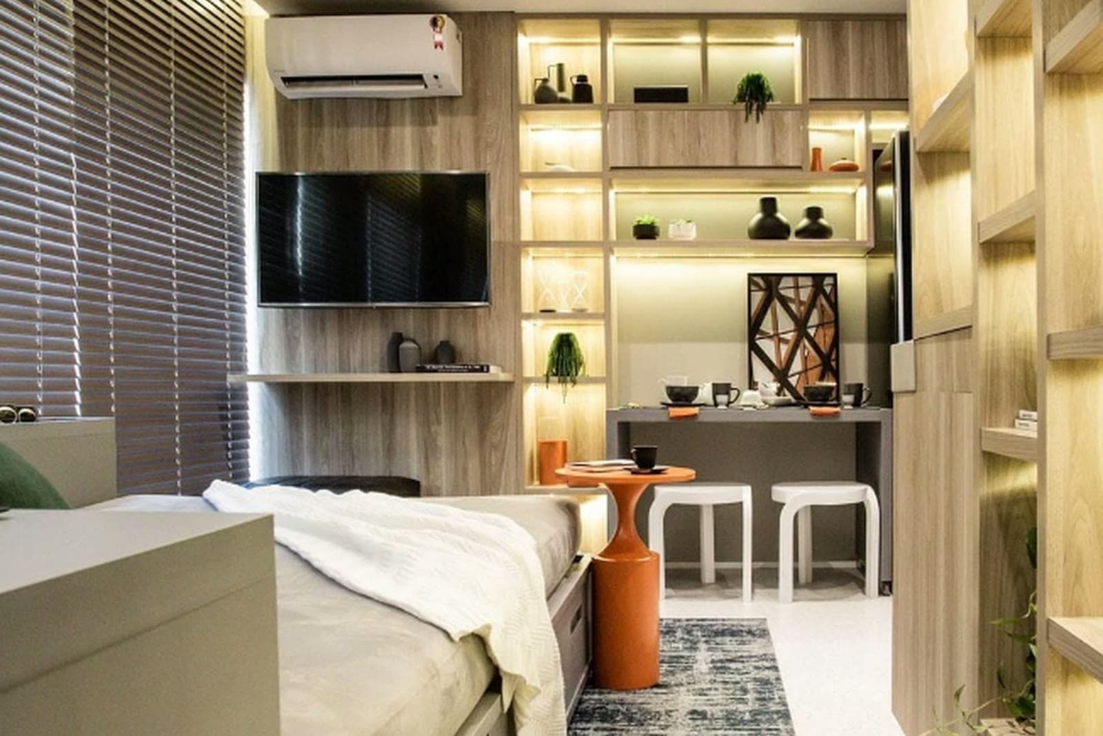 Studio decorado com marcenaria integrada, bancada e iluminação embutida, preparado para locação