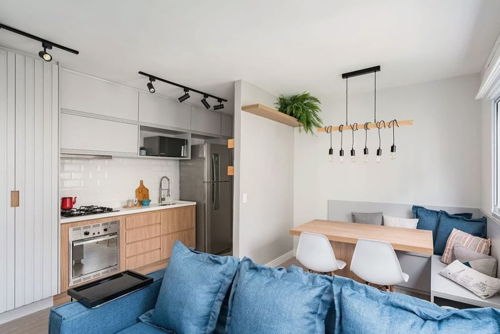 Studio decorado em São Paulo, com cozinha, mesa de refeições e sofá, preparado para receber hóspedes