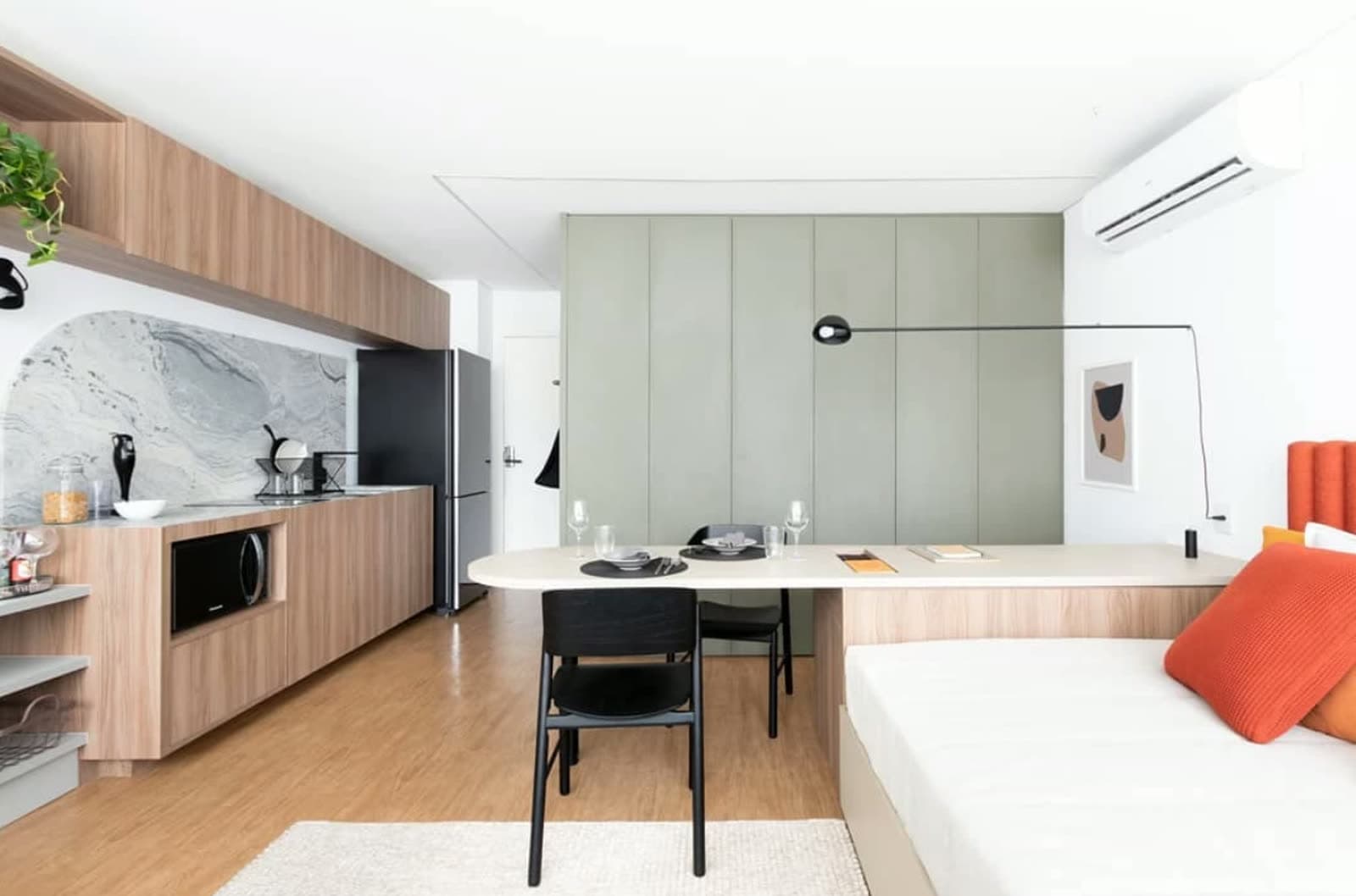 Cozinha e mesa de refeições de um studio decorado, pronto para receber hóspedes
