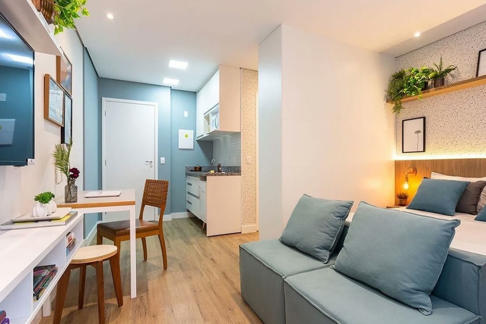 Studio decorado com marcenaria planejada e cozinha integrada, em bairro residencial de São Paulo